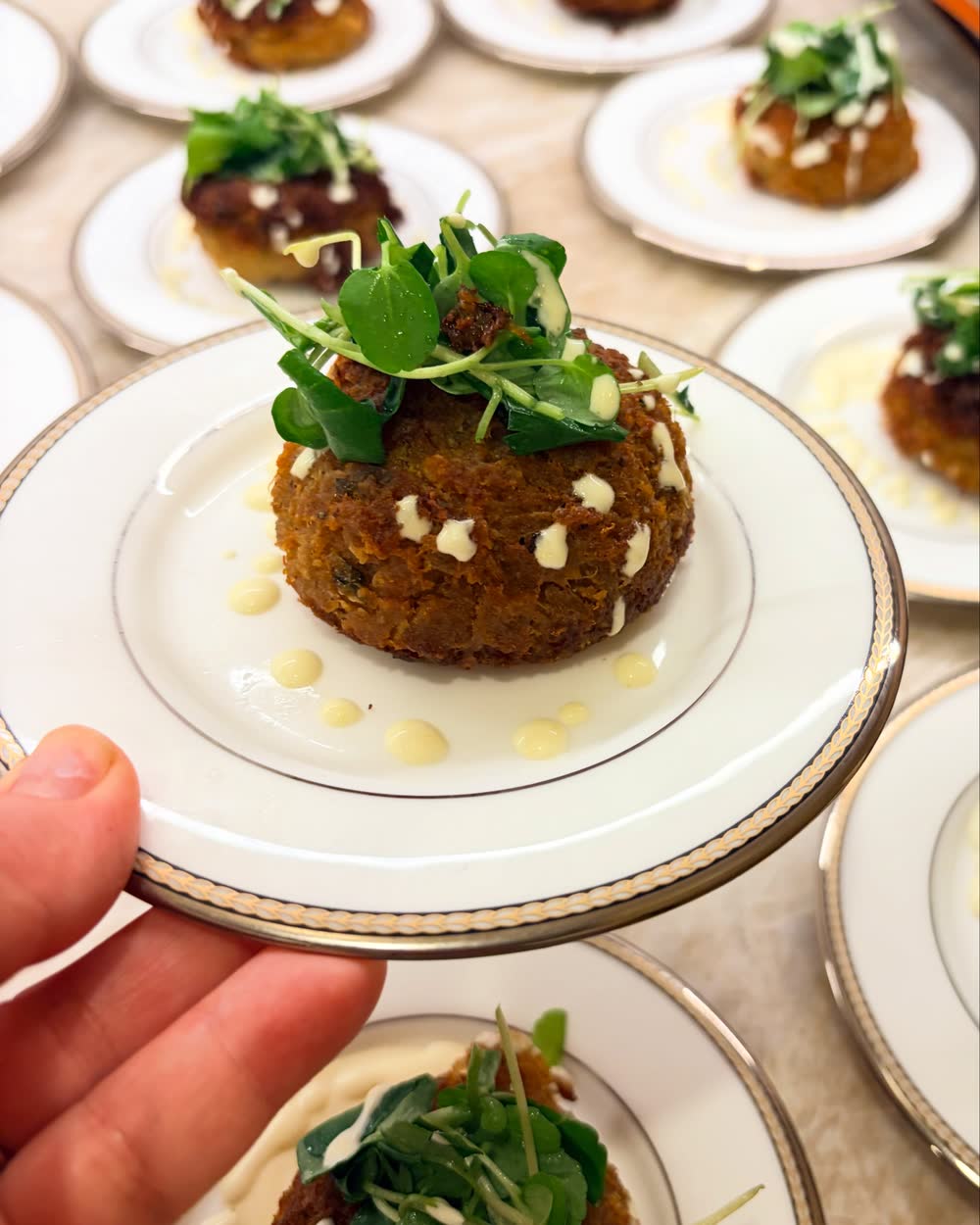 A plated crab cake with microgreens by a Nutrition Intuition chef